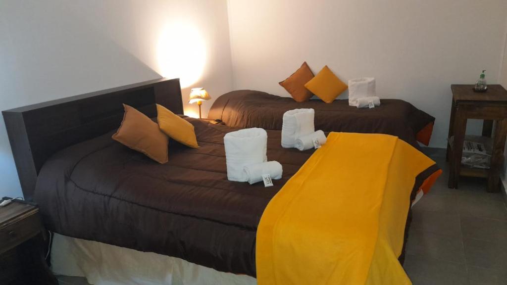1 dormitorio con 2 camas con sillas blancas en Santa Matilde Hospedaje en Malargüe