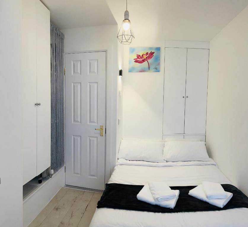a white bedroom with a bed with two pillows at CENTRAL HAVEN Minutes to Beach and Station in Brighton & Hove