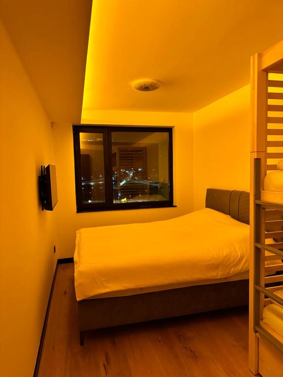 Habitación amarilla con cama y ventana en WinterHome2, en Bjelašnica