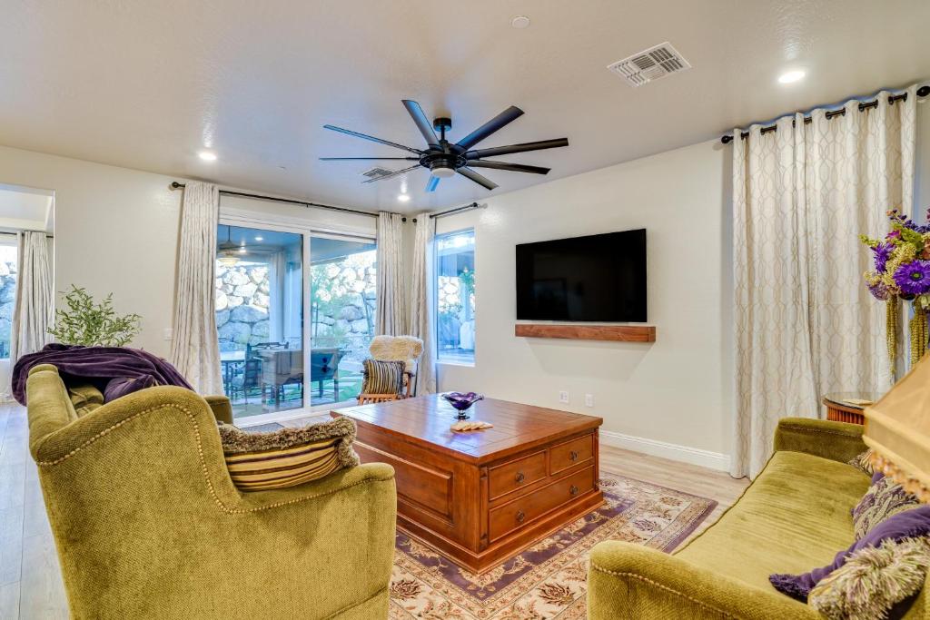 een woonkamer met 2 stoelen, een tafel en een tv bij Gorgeous Henderson Home with Patio and Yard! in Las Vegas