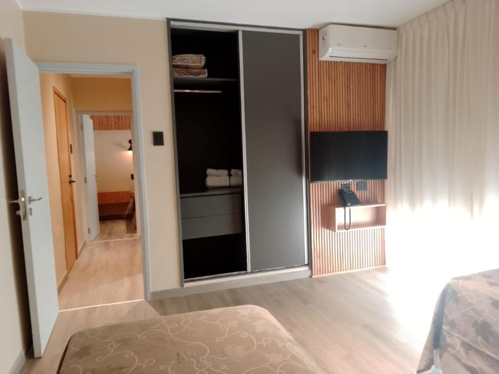 a living room with a large glass door to a bedroom at TERMAS PISMANTA Hotel & Spa in Las Flores
