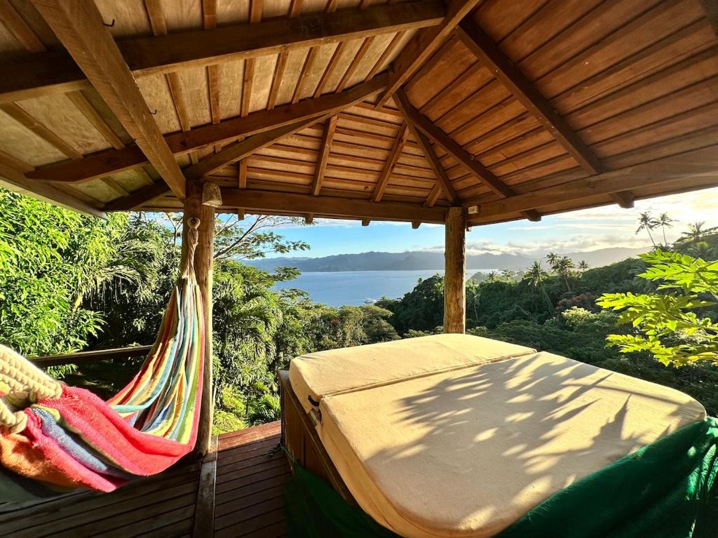 a hammock on a deck with a view of the ocean at Latui Lodge in Savusavu