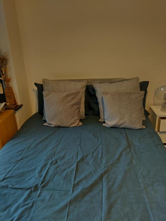 a bed with blue sheets and pillows on it at Westmorland in Cleveleys