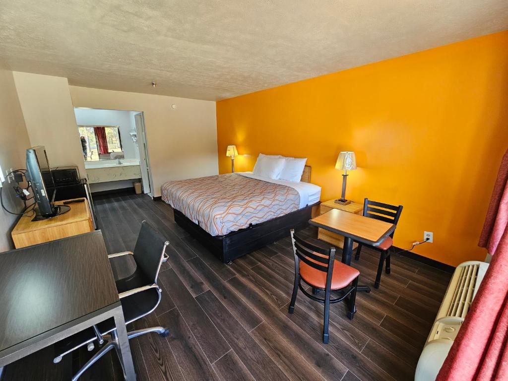 um quarto de hotel com uma cama, uma secretária e uma televisão em TRAVEL INN em Brandon