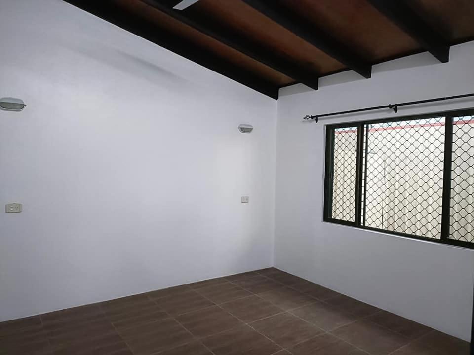 una stanza vuota con finestra e pareti bianche di Balabala Bed & Breakfast a Nadi