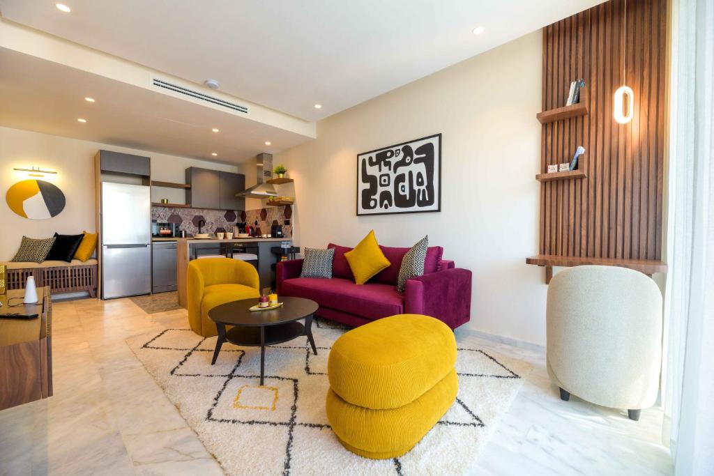 a living room with a purple couch and yellow chairs at Appartement luxueux et lumineux Maarif Casablanca in Casablanca