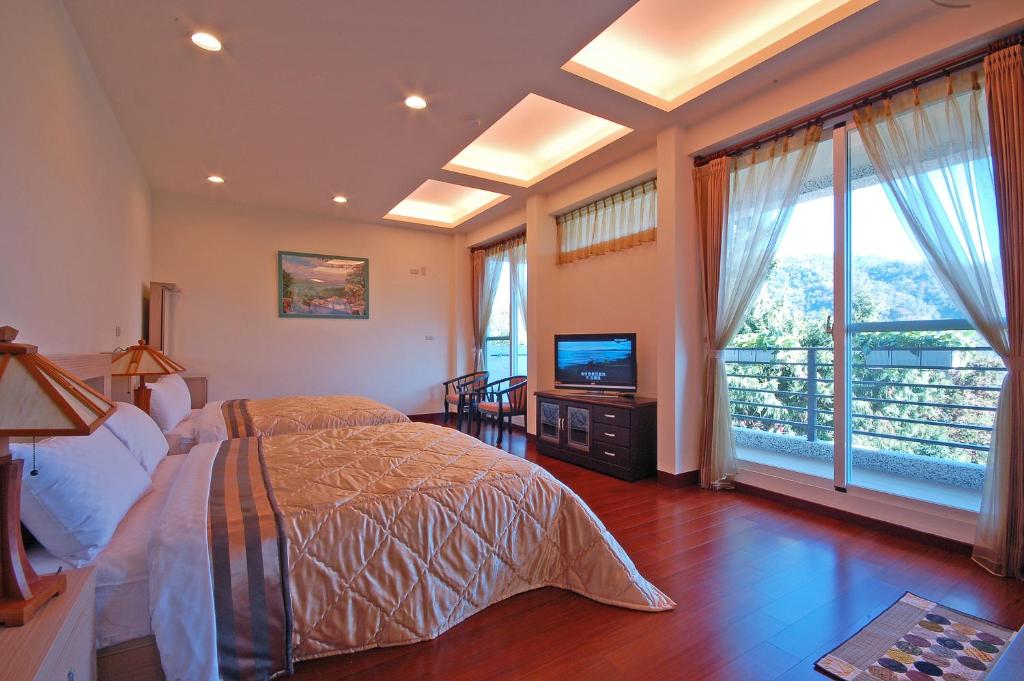 仁愛鄉的住宿－緹香景觀民宿，一间卧室设有一张床、一台电视和窗户。