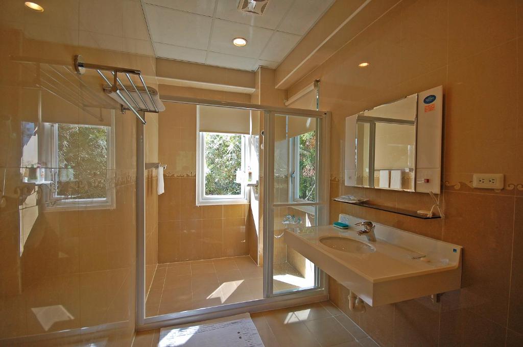 a bathroom with a glass shower and a sink at Ti Siang B&amp;B in Ren&#39;ai