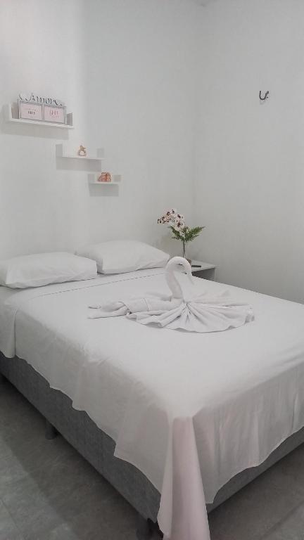 Una cama blanca con una manta blanca. en Casa d'lamour en Aracati