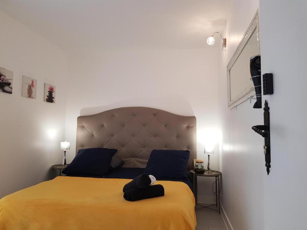 een slaapkamer met een geel bed met een hoed erop bij Chez Lisa & Olivier in Athis-Mons