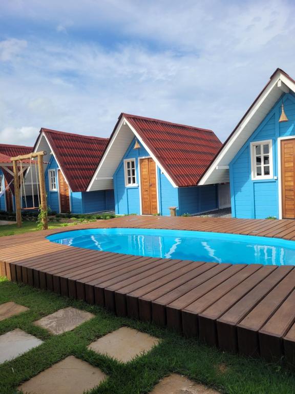 a row of houses with a swimming pool in front at Chalés Conexão Bahia in Amontada