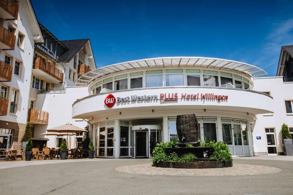 Best Western Plus Hotel Willingen في فيلنغن: مبنى ابيض كبير عليه لافته