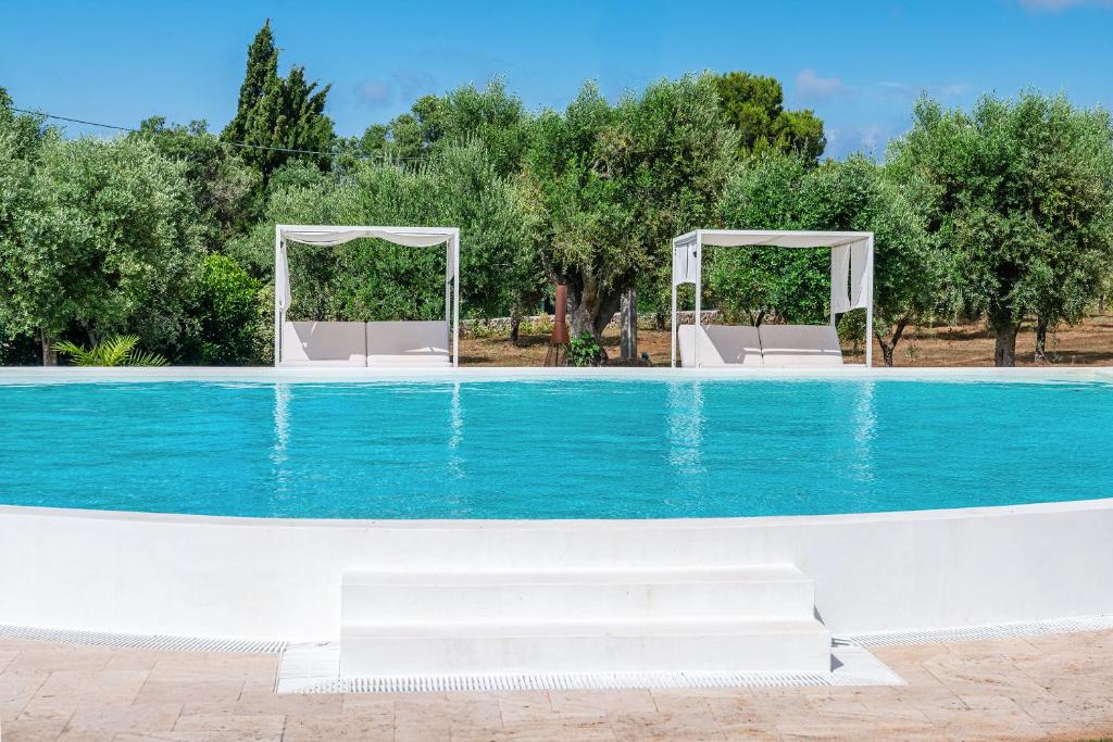 una piscina con due gazebo e acqua blu di Villa Clive Relax & Sun a Ostuni