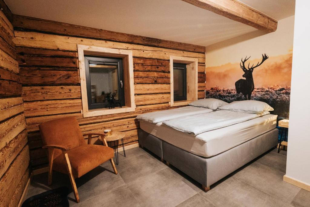 a bedroom with a bed and a painting of a deer at Nasza Chata in Duszniki Zdrój