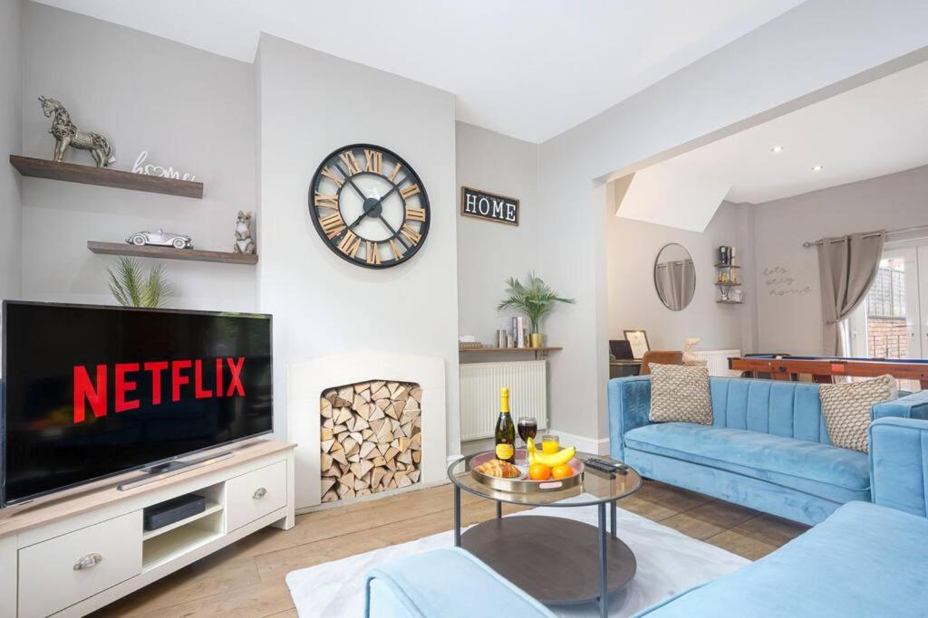 a living room with a tv and a blue couch at Central House with Parking, Pool Table, Super-Fast Wifi and Smart TV with Virgin Media and Netflix by Yoko Property in Northampton