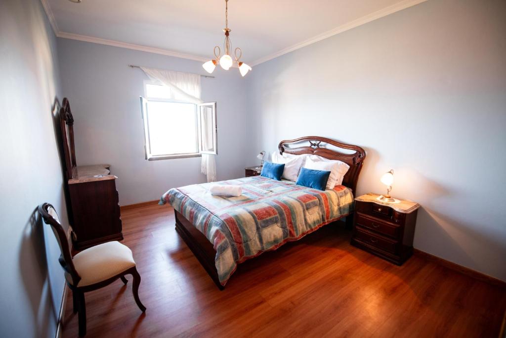 - une chambre avec un lit, une chaise et une fenêtre dans l'établissement Brisas do Atlántico, à Santa Maria Madalena