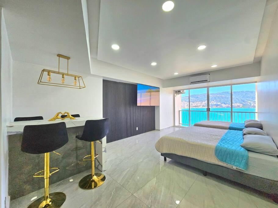 - une chambre avec un lit et un bureau avec des chaises dans l'établissement departamento con vista al mar, à Acapulco