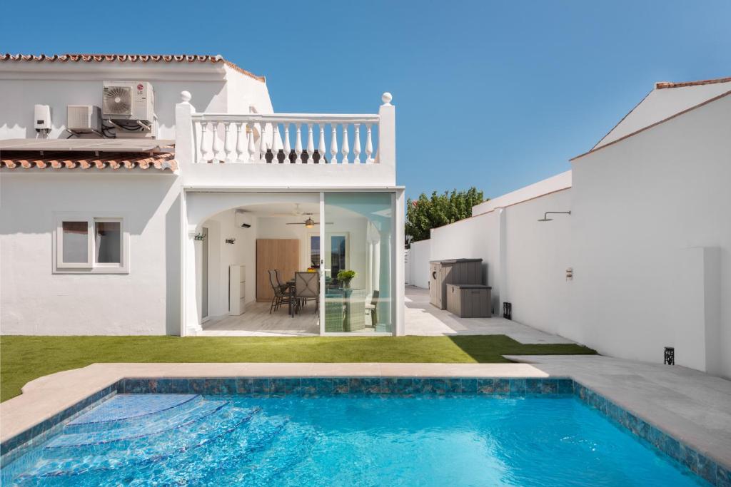 eine Villa mit einem Swimmingpool vor einem Haus in der Unterkunft Tooker Villa De La Playa La Cala de Mijas in La Cala de Mijas