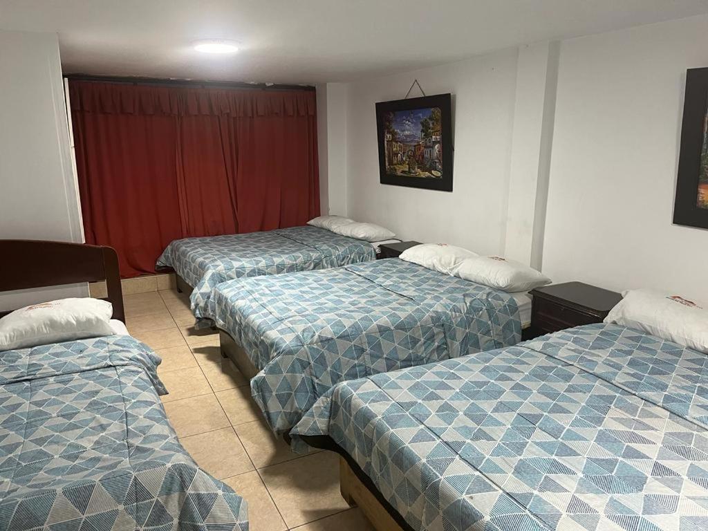 een kamer met drie bedden in een kamer bij HOTEL SAN VICENTE in Cajamarca