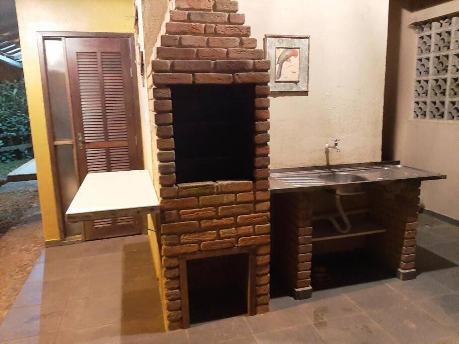 - une cheminée en brique avec lavabo dans la chambre dans l'établissement Alto Penedo, perto das cachoeiras,5 km do Centro., à Itatiaia