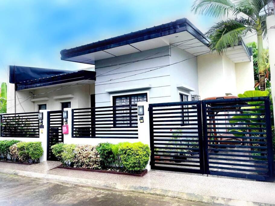 ein Haus mit einem schwarzen Zaun davor in der Unterkunft Home away from home. in Bacolod City