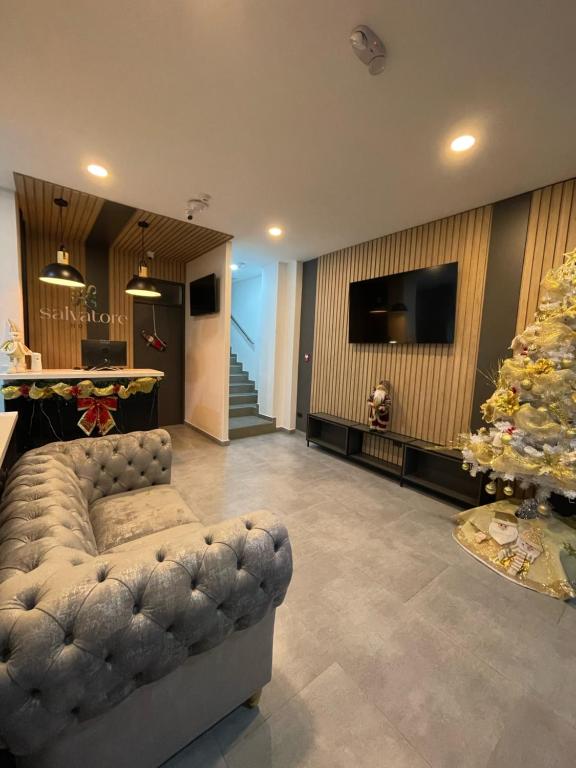 a living room with a couch and a christmas tree at HOTEL SALVATORE in Paipa