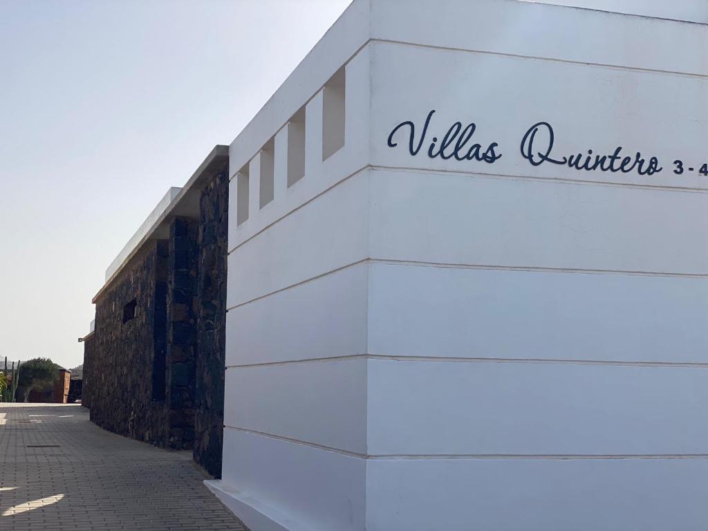 um edifício branco com um sinal na lateral em Villas Quintero em Tinguatón