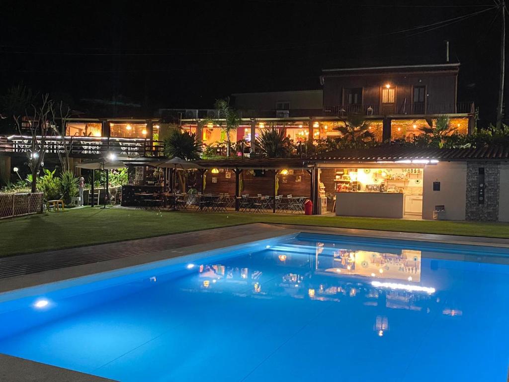 a swimming pool in front of a house at night at Casa do Lago in Amarante