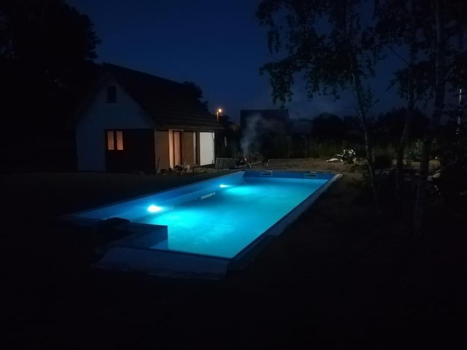 una piscina en un patio por la noche en Huisje in Słup, 