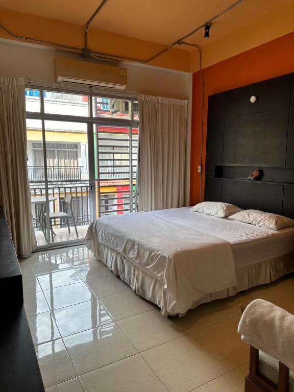 ein Schlafzimmer mit einem großen Bett und einem großen Fenster in der Unterkunft Cozy Place in Patong Beach