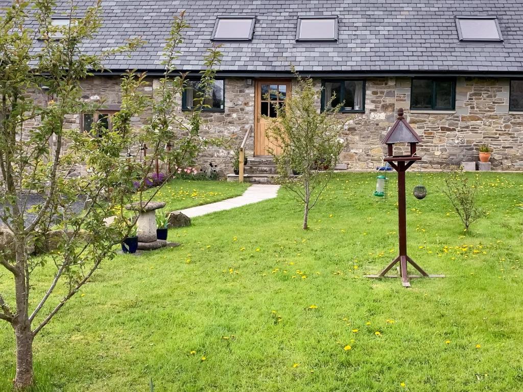 a house with a yard with a clock in the grass at Carnau Bach uk45822 in Llandegley