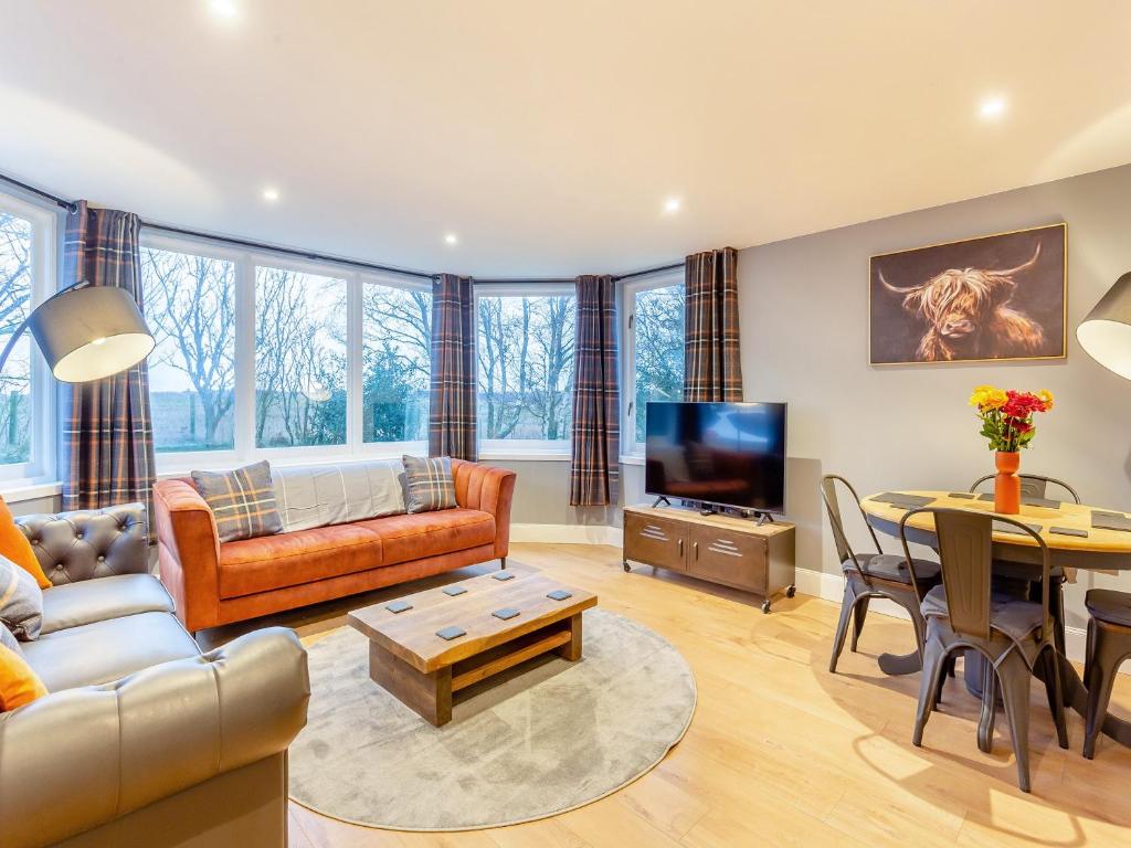 a living room with a couch and a table at East Tarrel Cottage in Portmahomack