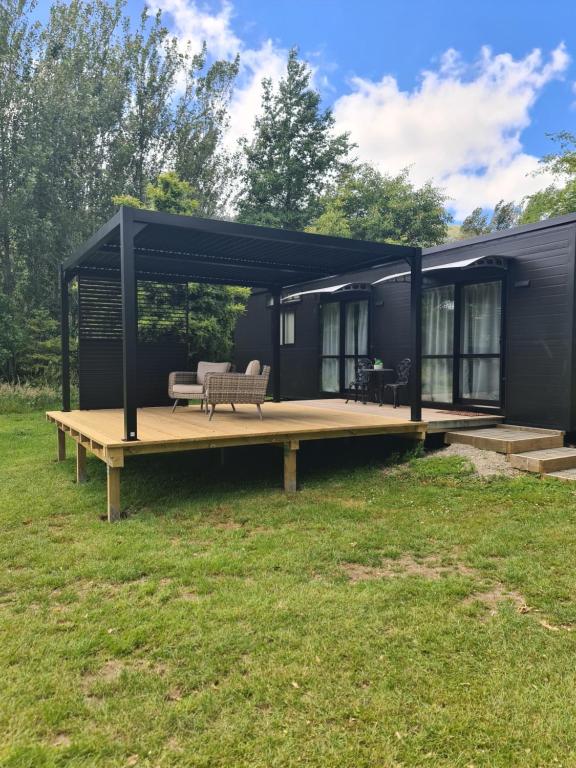 a black tiny house with a wooden deck at Private Country Cottage in Paraparaumu
