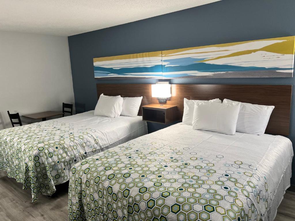 a hotel room with two beds and a painting on the wall at HomeTowne Studios by Red Roof Florence, KY-Cincinnati Airport in Florence