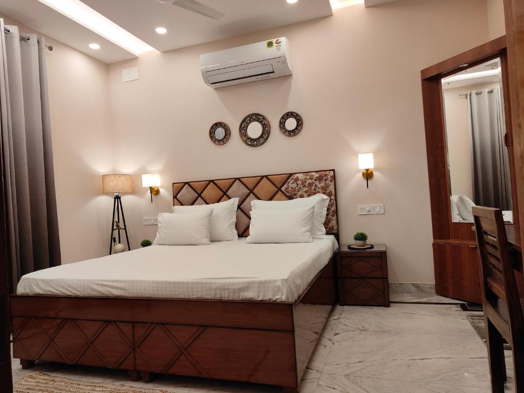 ein Schlafzimmer mit einem großen Bett mit weißer Bettwäsche in der Unterkunft Aura Home Stay in Mohali