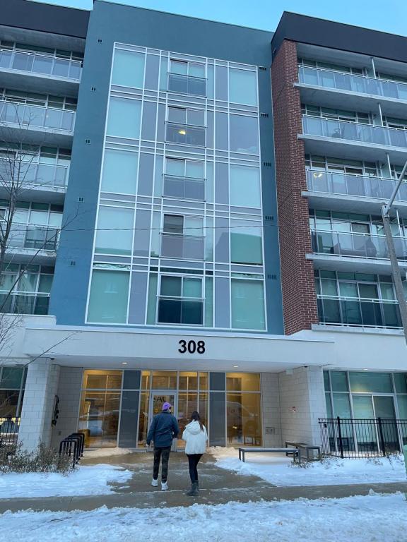 two people walking in front of a building at 1-bedroom condo near University of Waterloo in Waterloo