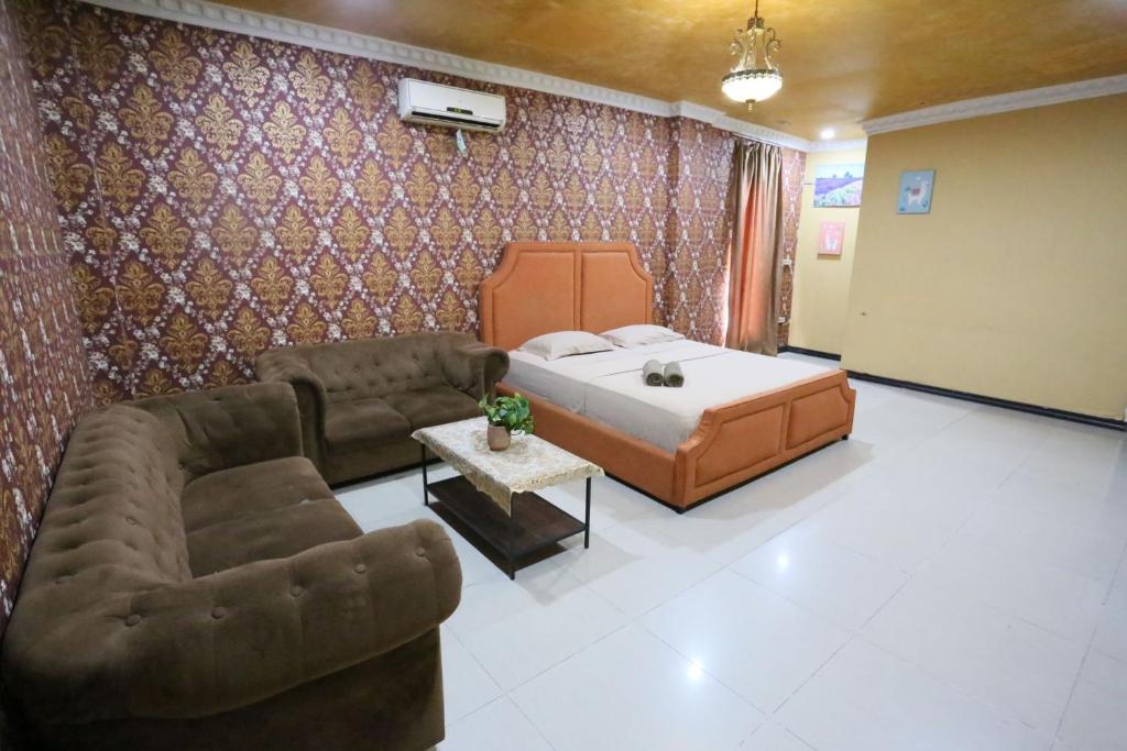 a living room with a bed and a couch at New Z Suites in Sunggal