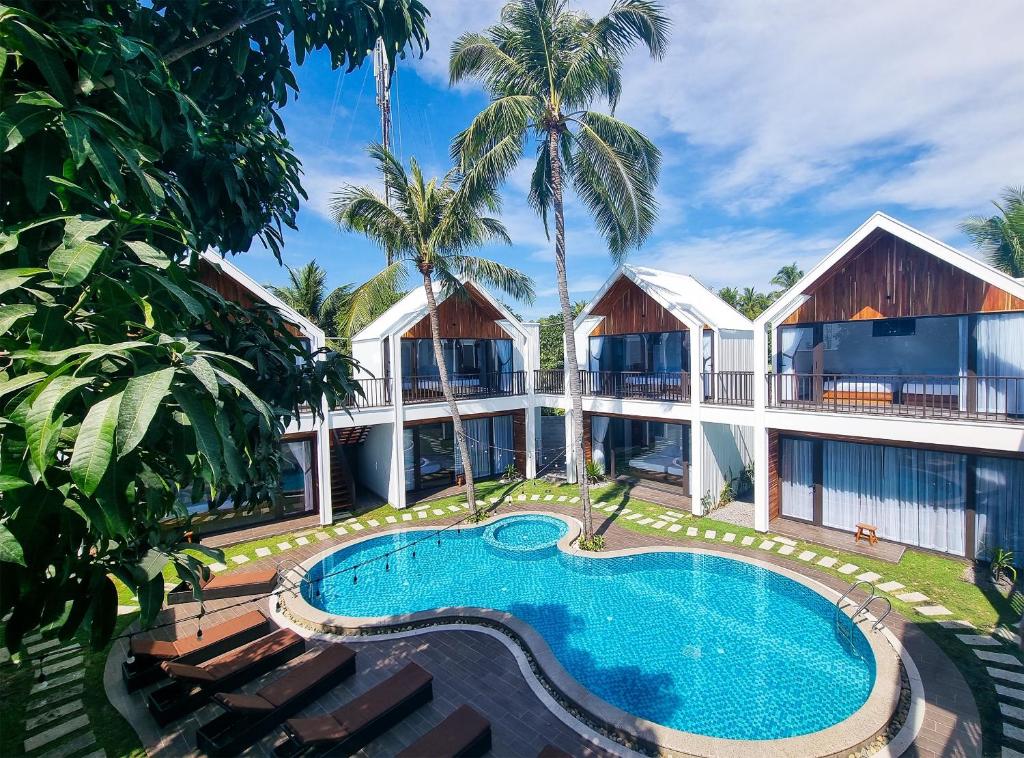 美奈的住宿－Tuong Vy Boutique Hotel Mui Ne，一座带游泳池的度假村,位于一座建筑前
