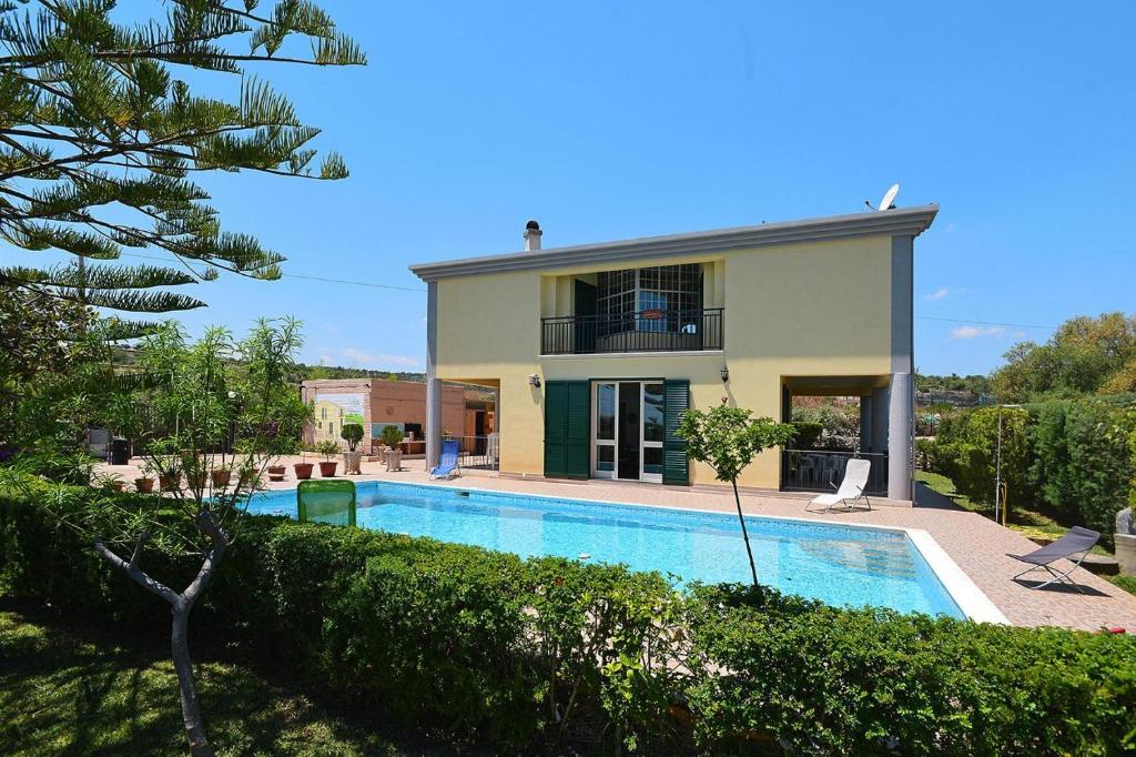 une villa avec une piscine en face d'une maison dans l'établissement Holiday Home Floridia - ISI02100i-F, à Floridia