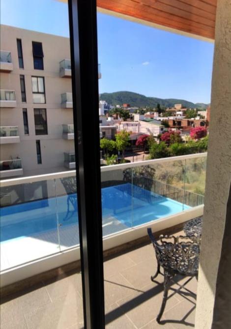 a balcony with a view of a swimming pool on a building at Accarezza in Villa Carlos Paz
