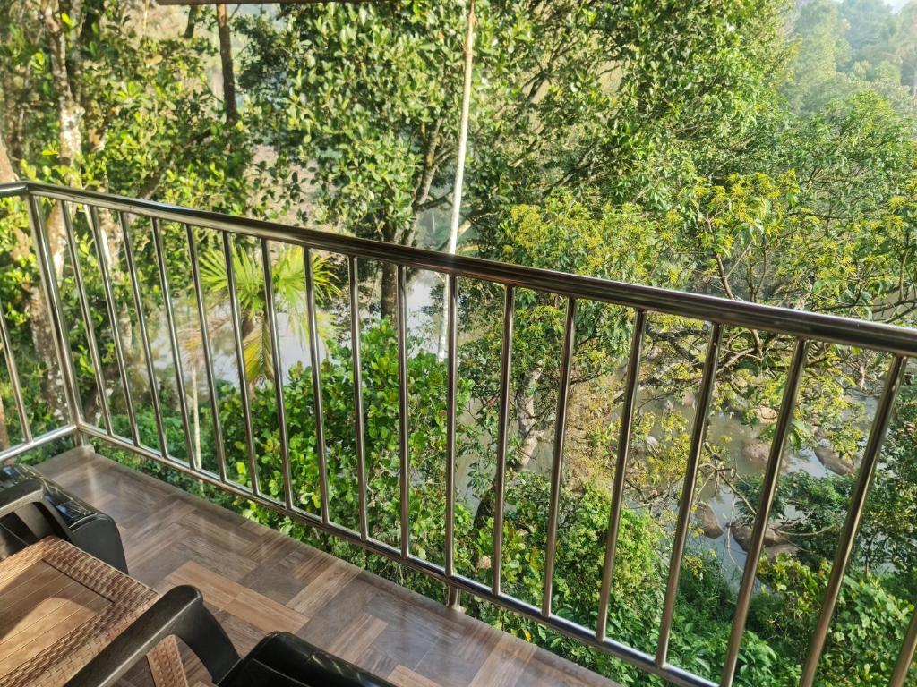 a balcony with a view of a waterfall at River Rock Homestay in Anachal