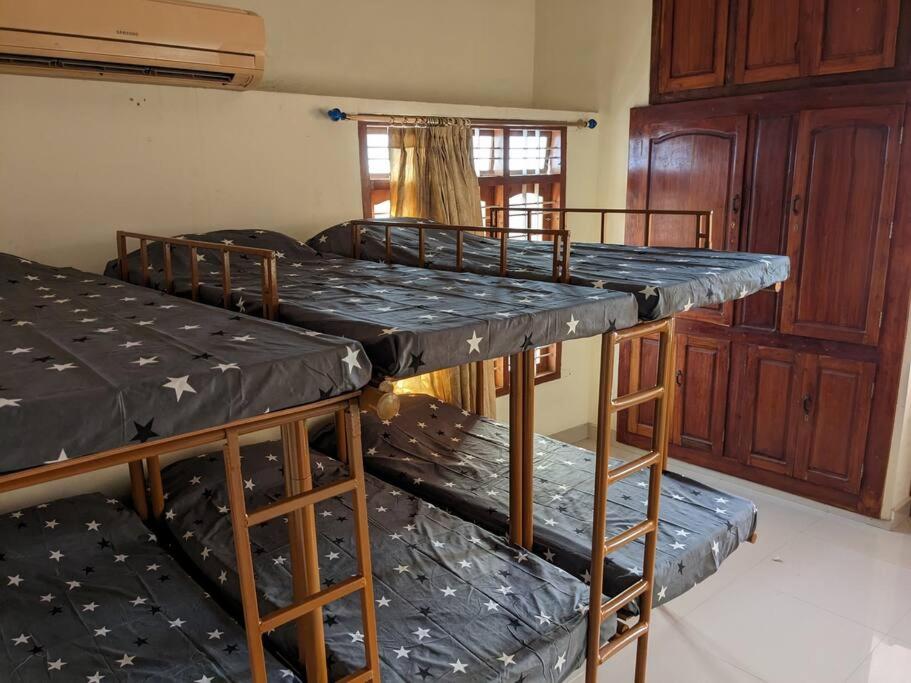two bunk beds in a room with black tarp at Modern City Oasis in Kollam