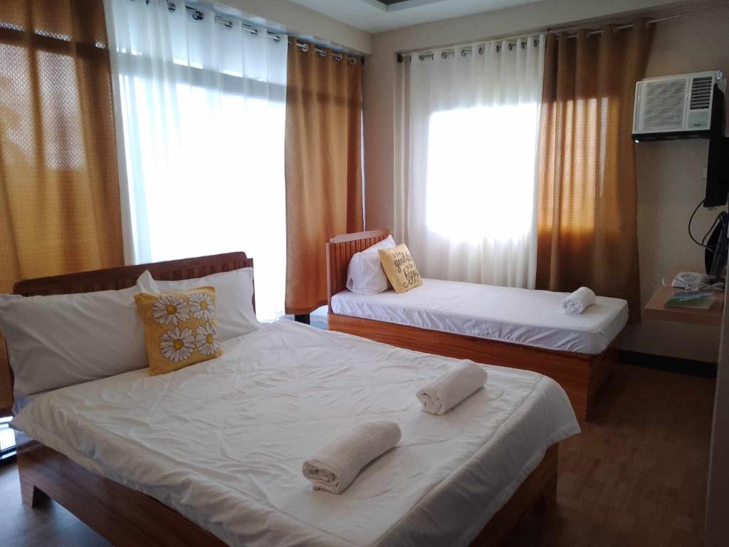 a bedroom with two beds and a window at SEAVIEW INN in Catbalogan
