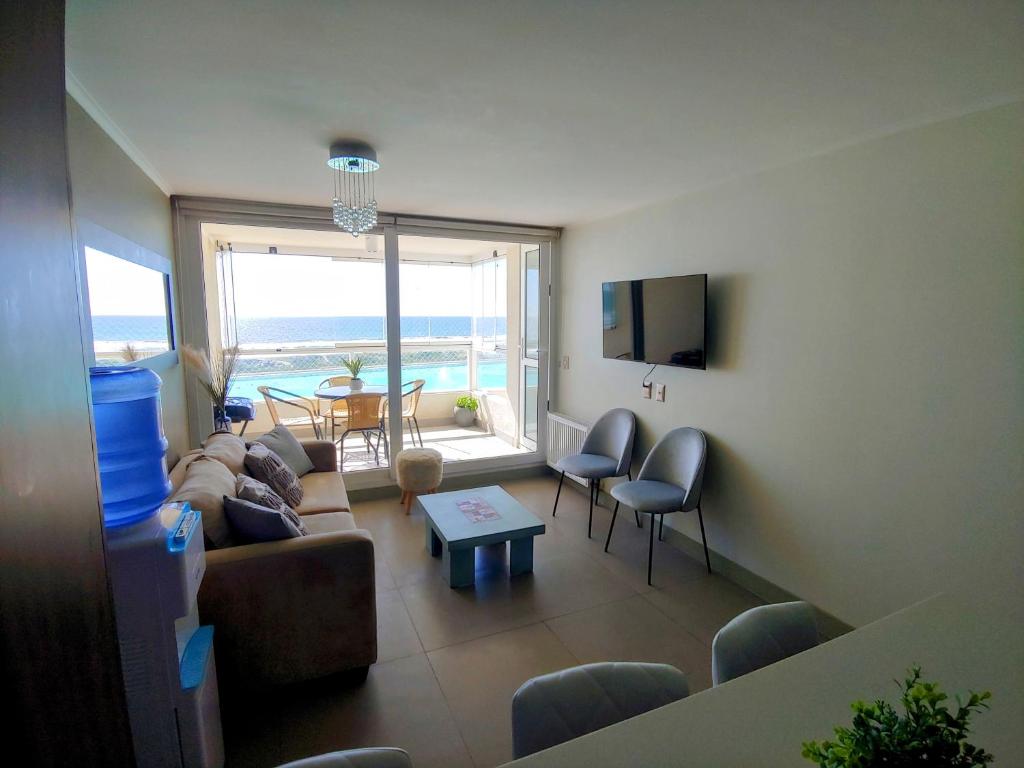 una sala de estar con un sofá y una mesa en Departamento Laguna del Mar, en La Serena