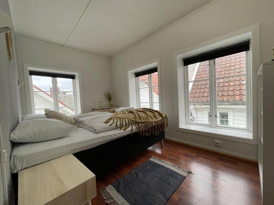 um quarto com uma cama num quarto com janelas em Stavanger BnB 15 by Berti's ( Centrum, Sauna, Billiard, Airport Shuttle) em Stavanger