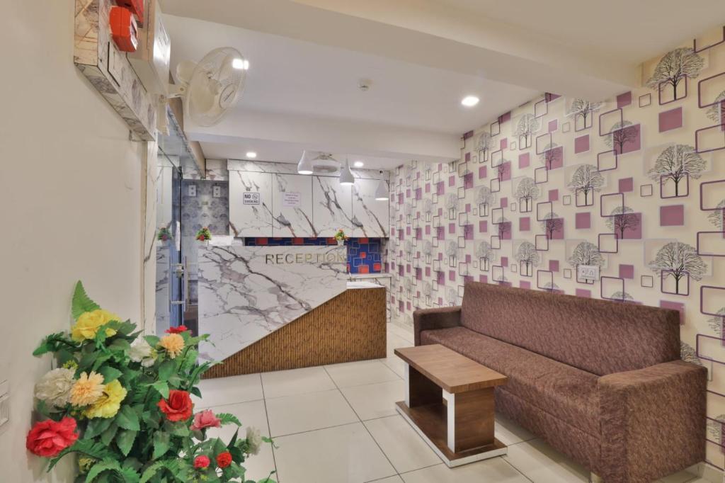 a lobby with a couch and flowers in a room at HOTEL REST INN in Gandhinagar