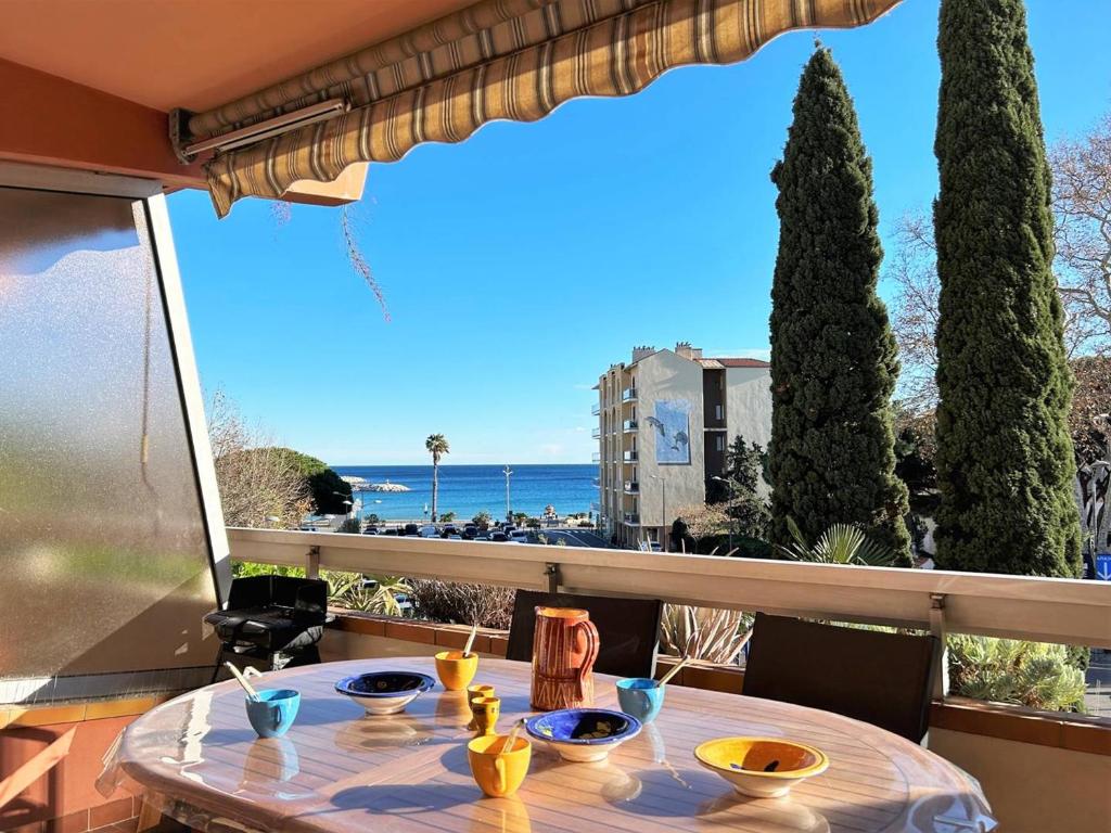 uma mesa numa varanda com vista para o oceano em Appartement Le Lavandou, 1 pièce, 4 personnes - FR-1-251-202 em Le Lavandou