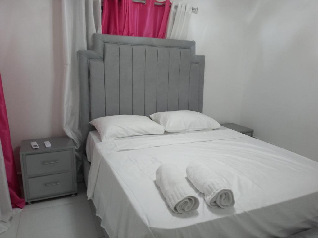 um quarto com uma cama com duas toalhas em Tu torre monumental Vl em Santiago de los Caballeros