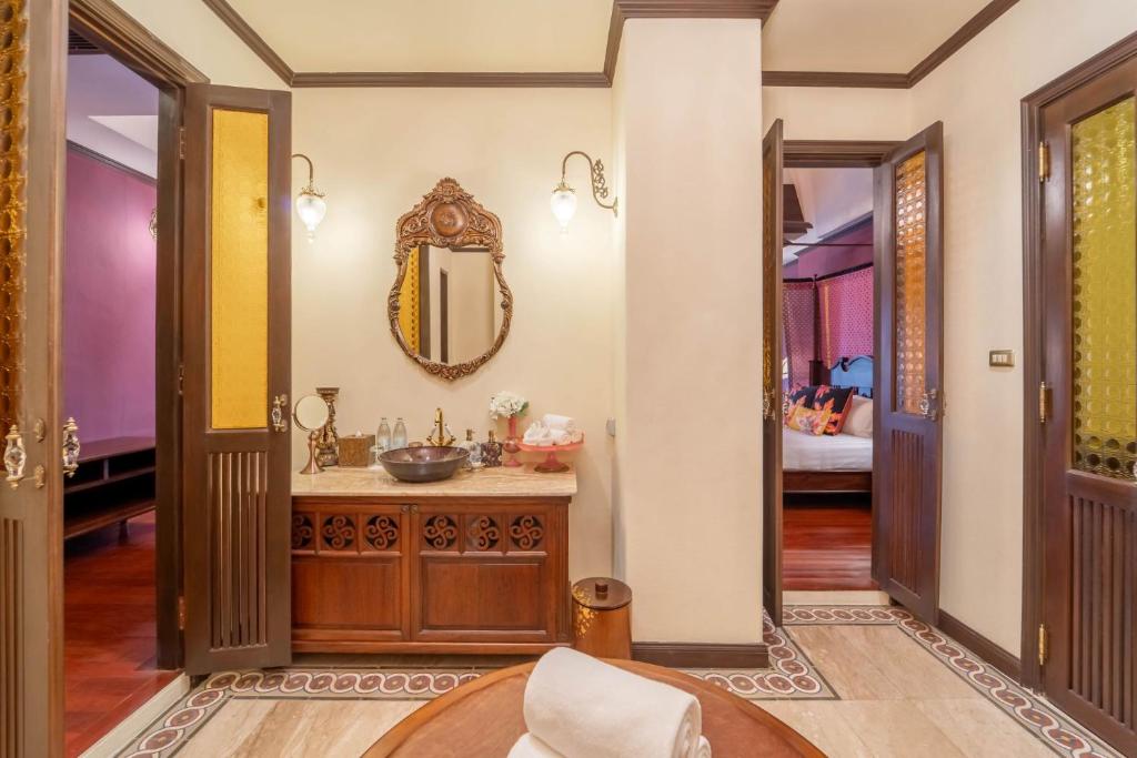 A traditional bathroom vanity with a carved wooden cabinet, bowl sink, and ornate mirror.