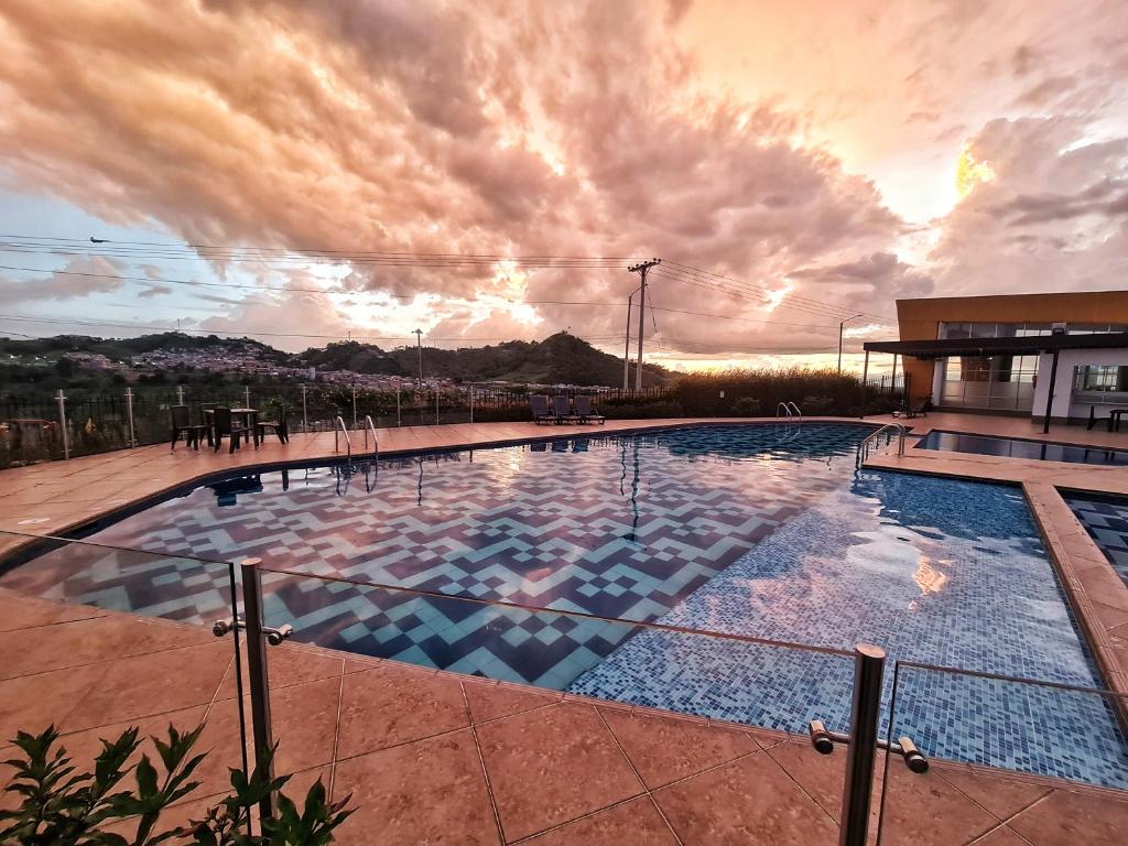 a swimming pool on top of a building with a sunset at Apartamento compartido en dosquebradas in Dosquebradas